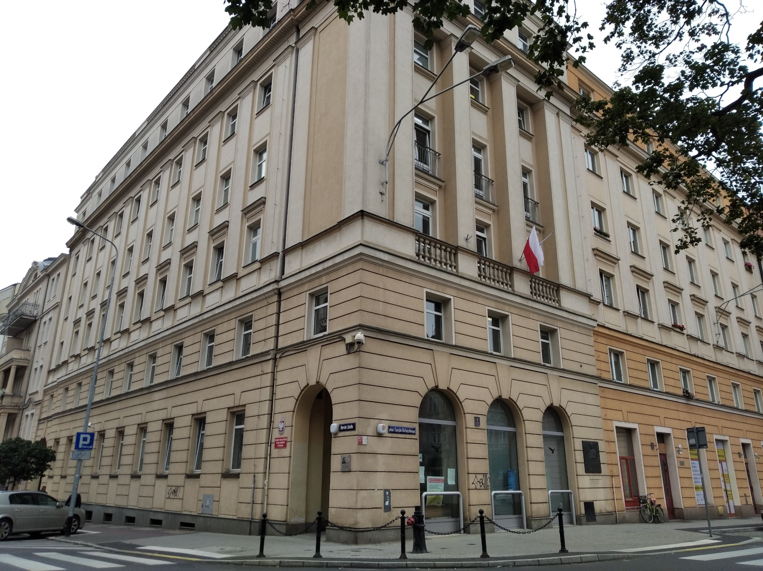 Na zdjęciu 4 - piętrowy budynek, elewacja w jasnym kolorze