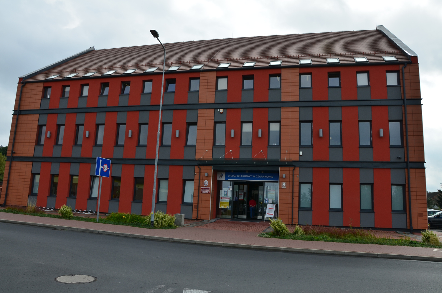 Na zdjęciu budynek 2 - Piętrowy budynek w elewacji koloru ceglastego