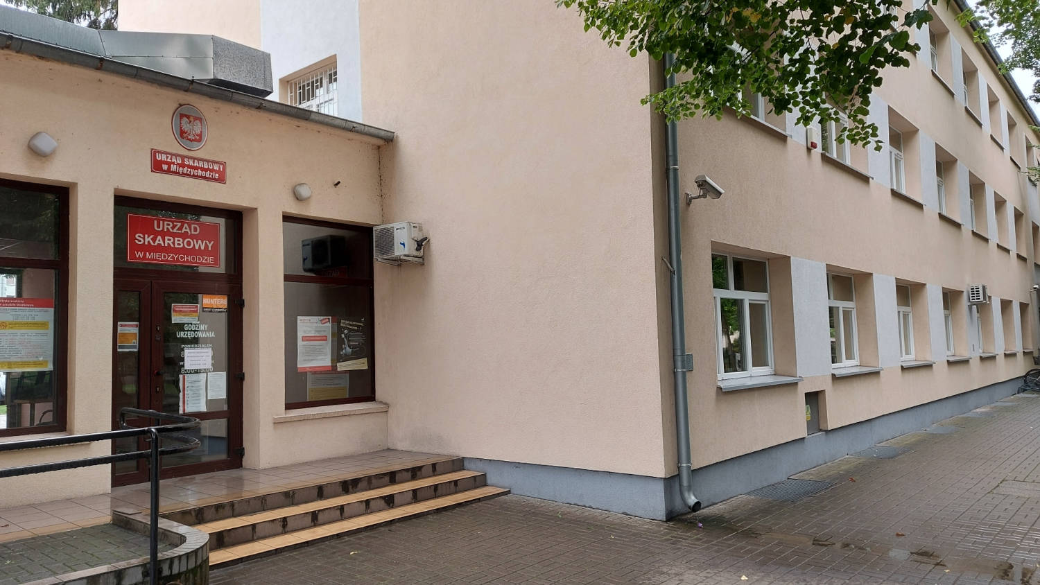 Na zdjęciu budynek w jasnoróżowej elewacji