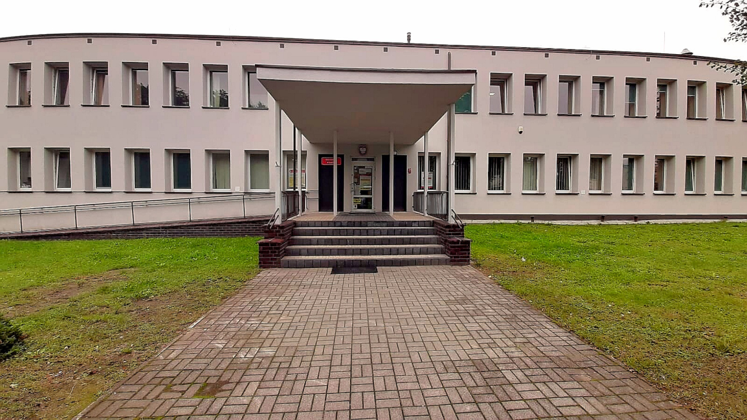 Na zdjęciu budynek w jasnoróżowej elewacji