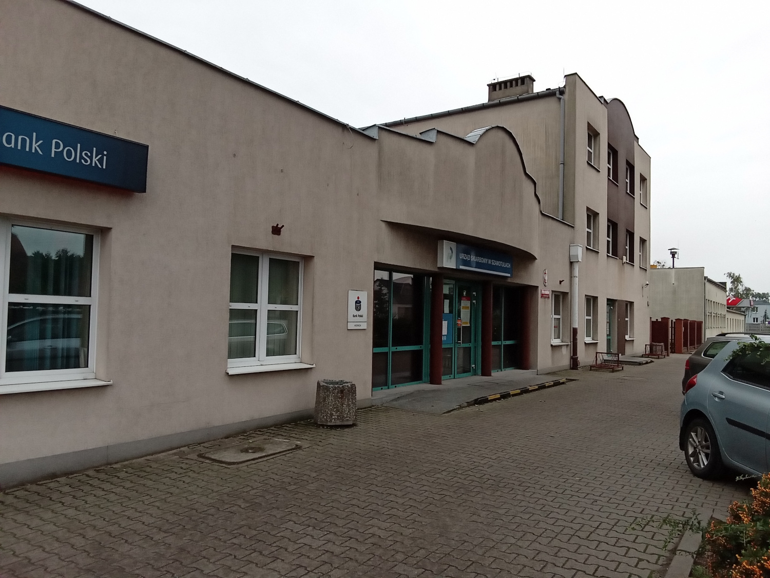 Na zdjęciu parterowy budynek w jasnobeżowej elewacji