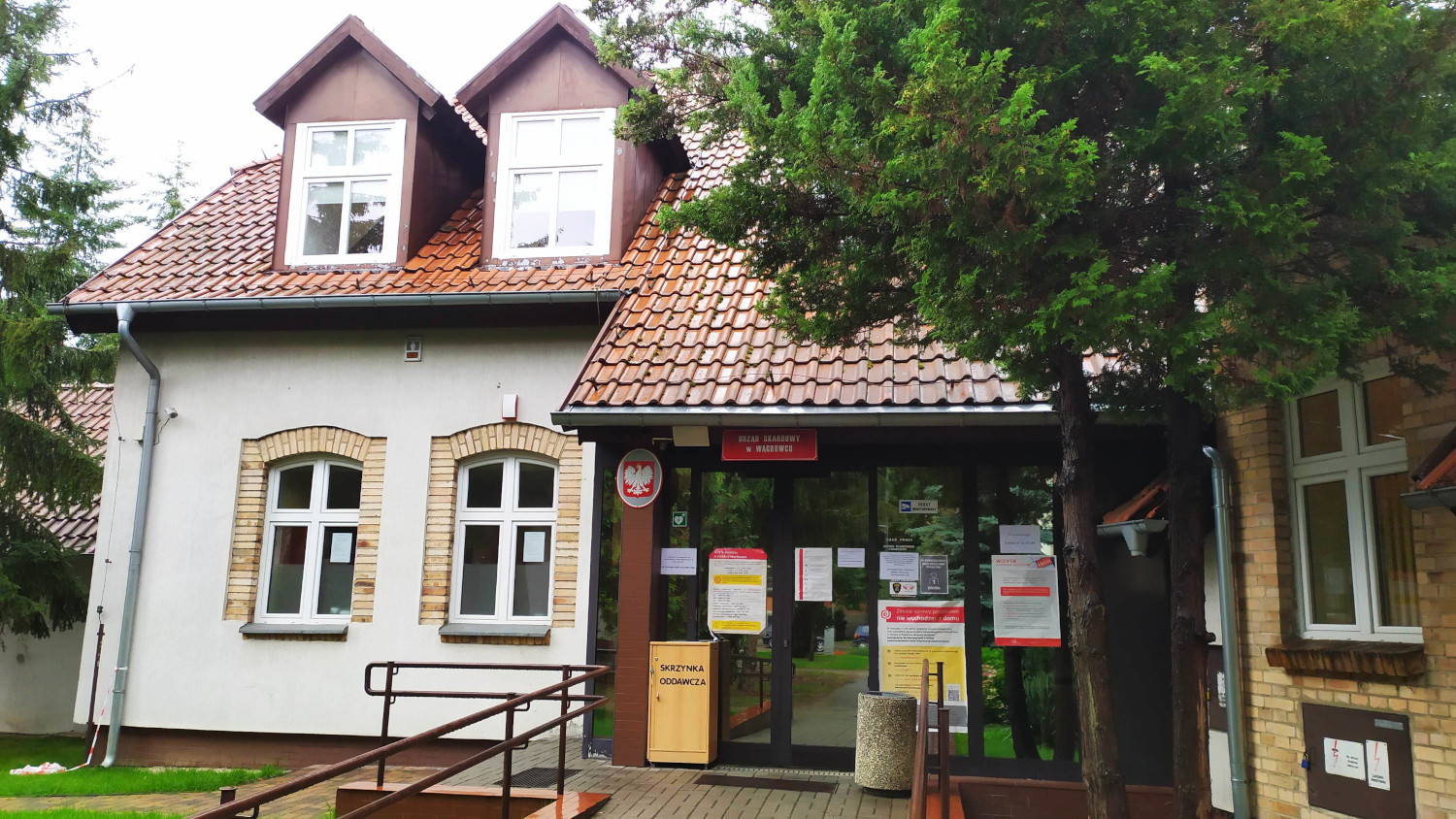 Na zdjęciu budynek elewacja koloru białego, przy oknach elementy cegieł