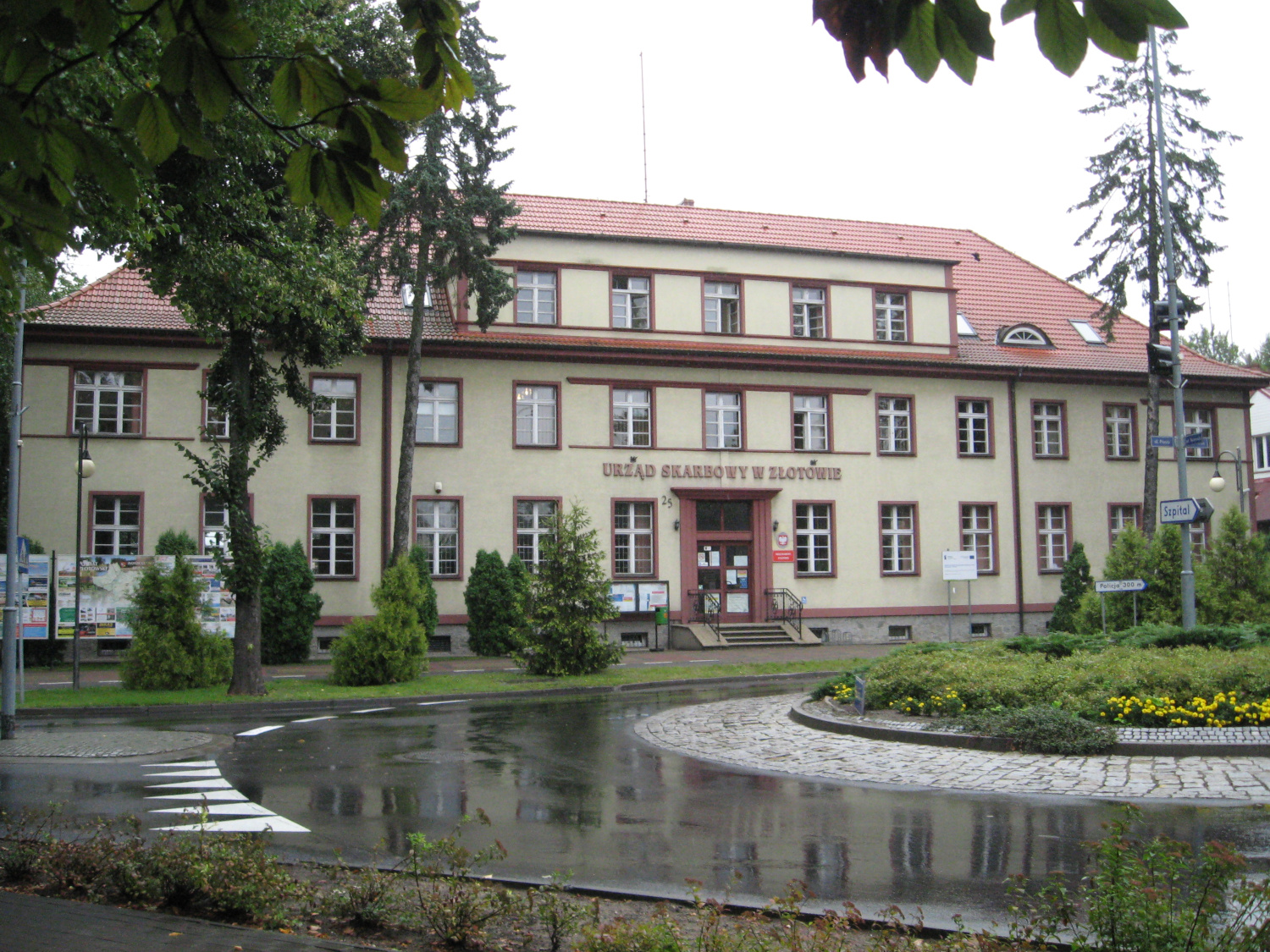 Na zdjęciu budynek w jasnej elewacji, obramowania wokół okien w kolorze cegły