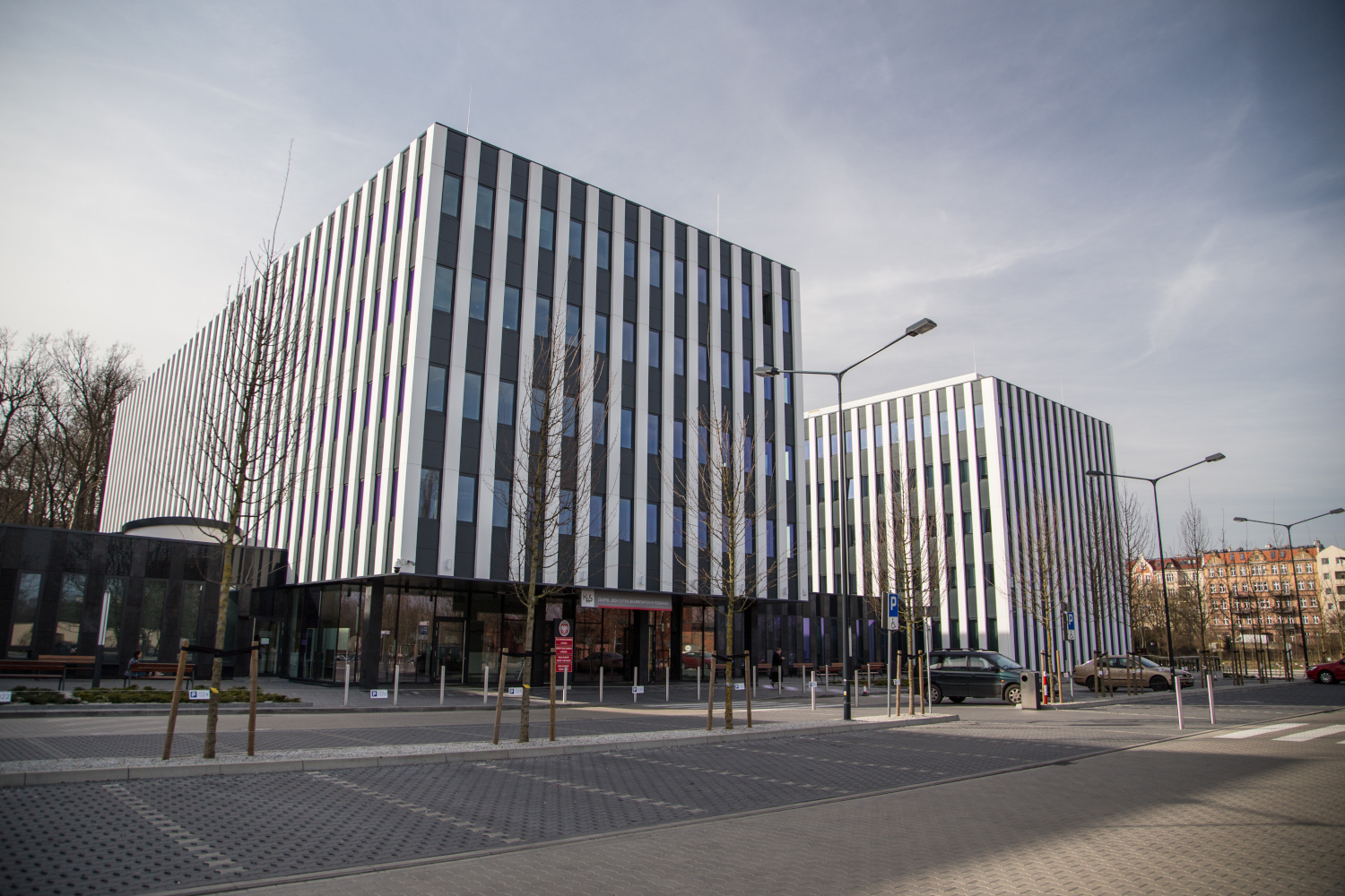 Na zdjęciu wysoki jasny budynek z wąskimi oknami