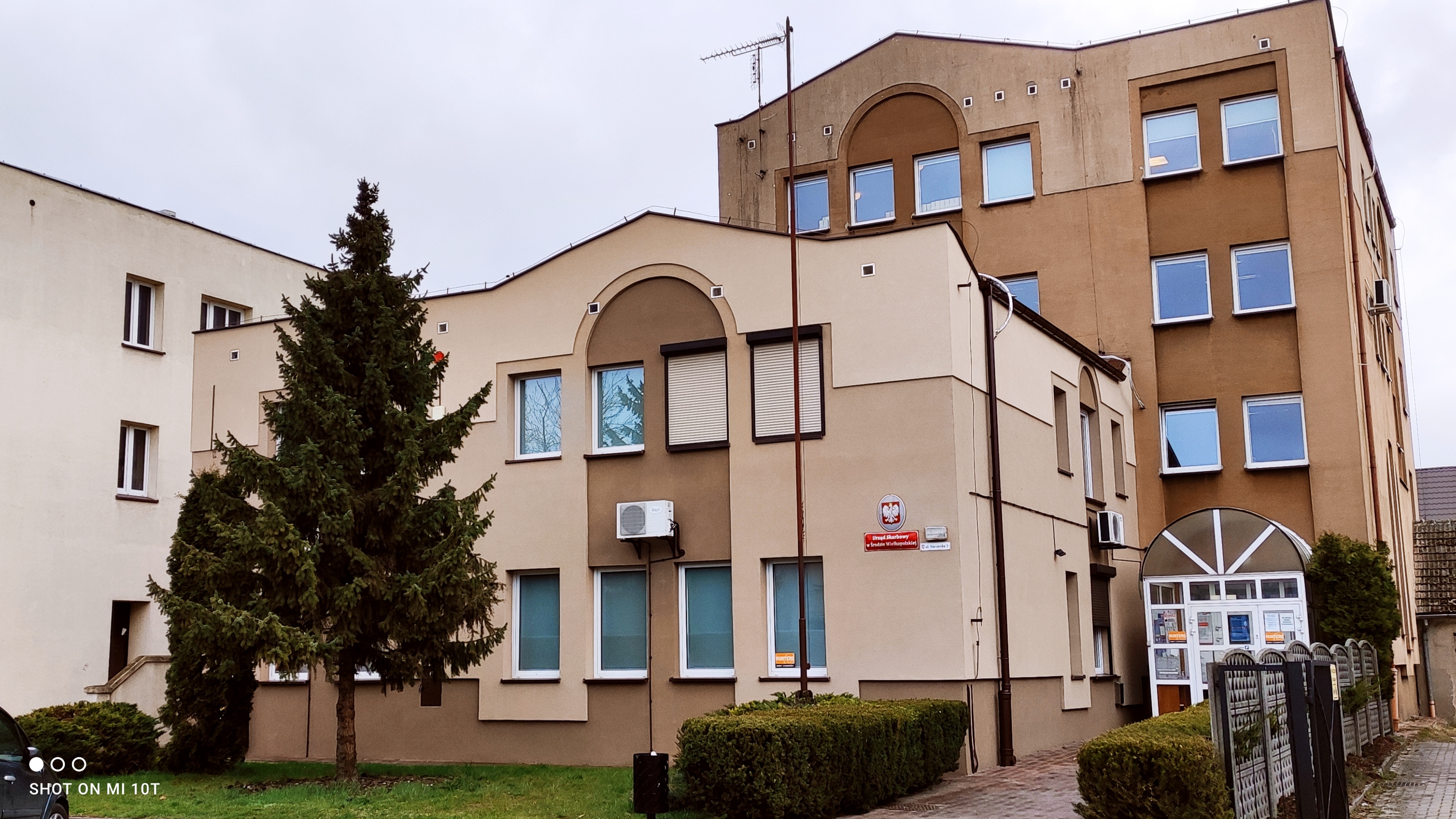 Na zdjęciu budynek w jasnoróżowej elewacji z elementami w kolorze jasnobrązowym