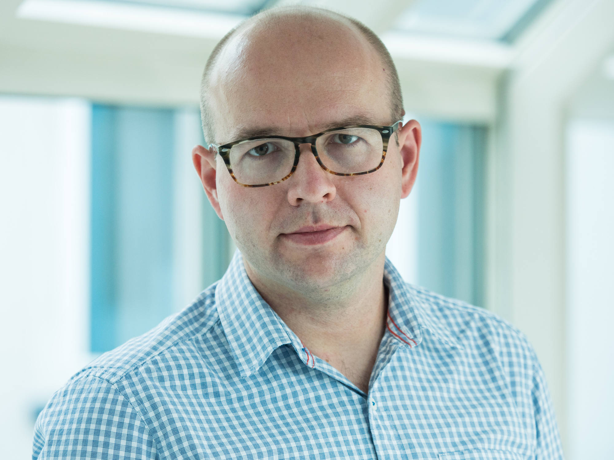 Michał Kasprzak, Rzecznik prasowy - mężczyzna, ubrany w koszulę w kratkę, na nosie okulary