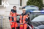 Dwóch ratowników medycznych stoi przy samochodzie Służby Celno-Skarbowej