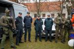 Siedmiu funkcjonariuszy Służby Celno-Skarbowej stoi przed stoiskiem informacyjno-edukacyjnym 