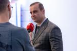 Szef Krajowej Administracji Skarbowej Bartosz Zbaraszczuk stoi przed kamerą i udziela wywiadu