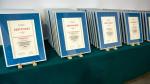Ustawione na stoliku dyplomy dla wyróżnionych urzędów skarbowych
