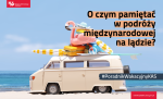 Po drodze jedzie biały samochód VAN zapakowany po dach artykułami kojarzącymi się z wakacyjną wyprawą. Na jego tle znajduje się napis: O czym pamiętać w podróży międzynarodowej na lądzie ?