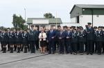 Grupowe zdjęcie funkcjonariuszy i pracowników Krajowej Administracji Skarbowej oraz zaproszonych gości, wykonane podczas uroczystości przed budynkiem administracyjnym.