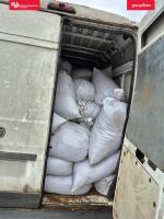 Przestrzeń ładunkowa pojazdu wypełniona białymi, jutowymi workami - widok z tyłu pojazdu